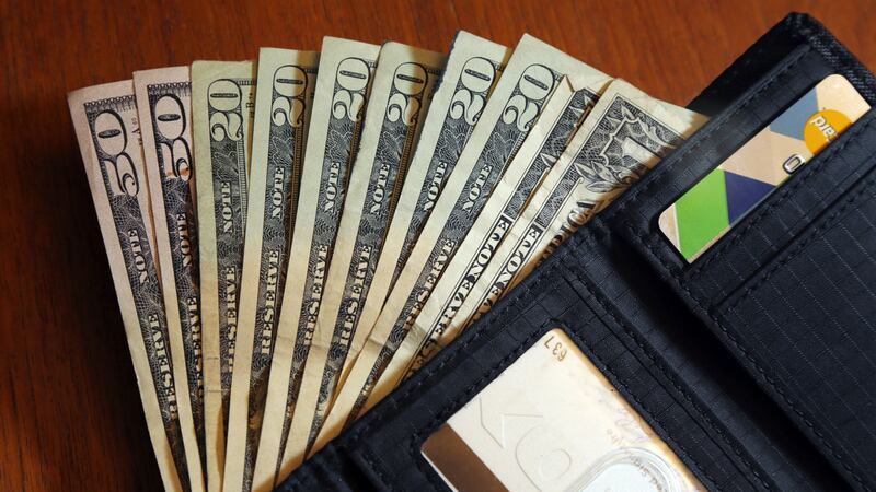 FILE - In this June 15, 2018 file photo, cash is fanned out from a wallet in North Andover, Mass.
