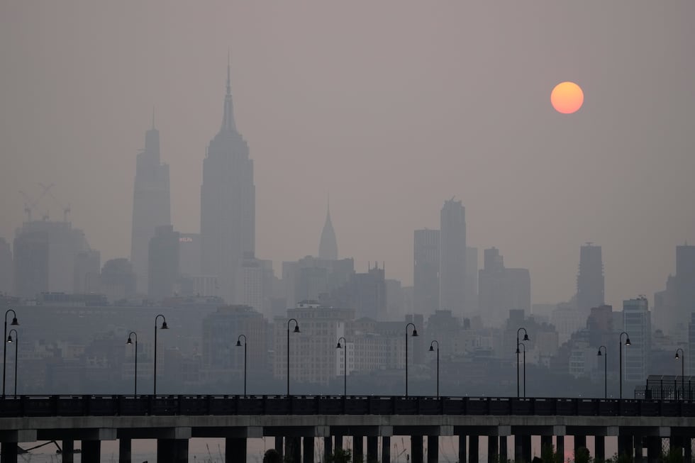 The sun rises over a hazy New York City skyline as seen from Jersey City, N.J., Wednesday,...