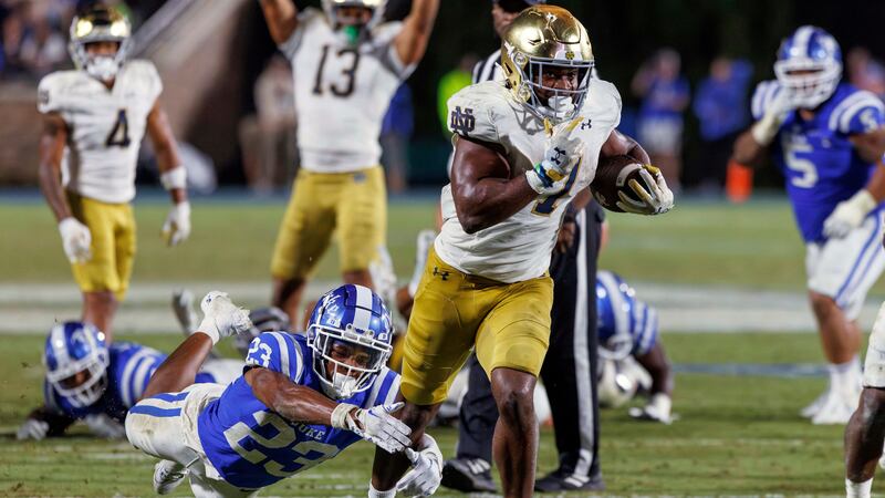Notre Dame's Audric Estimé (7) carries the ball past Duke's Terry Moore (23) for the go-ahead...